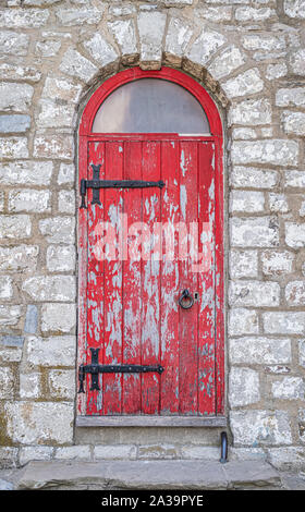 Gut verwitterte alte rote Tür am Eingang zum Gibraltar Point Leuchtturm auf Toronto Island. Stockfoto