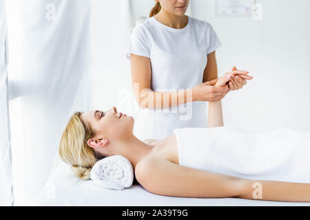 7/8-Ansicht von Masseur, Handmassage, attraktive Frau Stockfoto