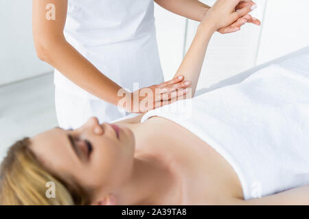 7/8-Ansicht von Masseur, Handmassage, attraktive Frau Stockfoto