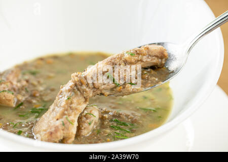 Eine Schale hausgemachter chili Linsensuppe mit Fleisch auf Holztisch. Restaurant Menü Stockfoto