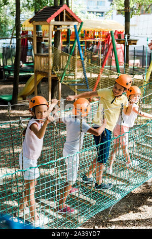 Cute multikulturellen Kinder Helme in der Nähe der bunten Holzkonstruktion Stockfoto