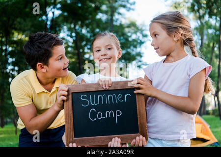 Adorable Kinder holding Kreidetafel mit Summer Camp Buchstaben Stockfoto