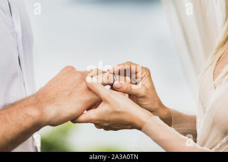 Braut die Hochzeit Ring an der Hand des Bräutigams. Symbol der Liebe und Engagement. Stockfoto