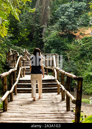Junge modische Frau auf einem Bambus Brücke Stockfoto