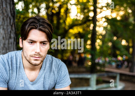 Junger Mann, Modell, posiert im Freien auf der Suche nach einem Tag bei der Arbeit müde. Stockfoto