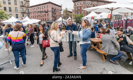 New York, NY - Oktober 6, 2019: Festivalbesucher genießen Sie Essen und Trinken während der New York Pizza Festival in der Crescent Avenue in der Bronx Stockfoto