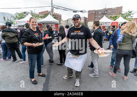 New York, NY - Oktober 6, 2019: Festivalbesucher genießen essen Pizza während der New York Pizza Festival in der Crescent Avenue in der Bronx Stockfoto