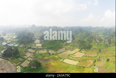 Luftaufnahme von Ninh Binh region, Trang Ein Tam Coc touristische Attraktion, UNESCO-Weltkulturerbe, malerischen Fluss Crawlen durch karst Bergketten Stockfoto