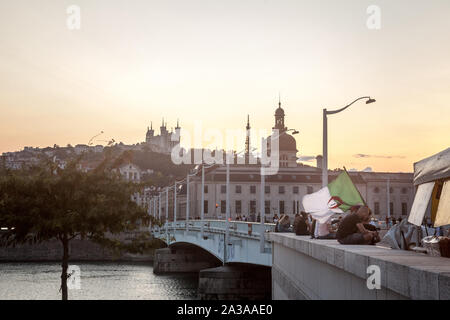 LYON, Frankreich - 14 Juli, 2019: Der Mann, der den Verzicht auf eine algerische Fahne im Zentrum von Lyon, mit Sehenswürdigkeiten wie die Basilika Notre Dame De Fourviere Kirche, Stockfoto