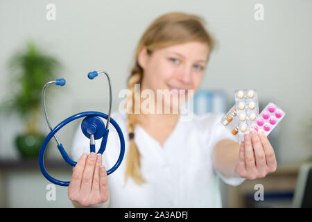 Krankenschwester leitet ein Stethoskop und Blasen von Tabletten Stockfoto