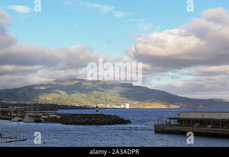 Schöne Aussicht auf das Meer, die Berge, Wolken und Wellenbrecher von Ponta Delgada Sao Miguel, Azoren, Portugal Stockfoto