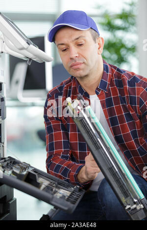 Mann der Wartung eines industriellen Fotokopierer Stockfoto