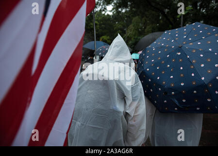 Hongkong, China. 06 Okt, 2019. Eine Demonstrantin trägt eine amerikanische Flagge während der Demonstration. Demonstranten marschierten durch verschiedene Stadtbezirke in Hongkong in der letzten Runde der Proteste. Während die Demonstration friedlich begann, Bereitschaftspolizei kamen später auf einer Streuung Betrieb durchzuführen, was zu mehreren Festnahmen. Die Demonstranten gegen die Regierung weiterhin ihre "5 Forderungen" gehört, da sie sich auf die Regierung und die Polizei Warnungen Woche für Woche trotzen weiter zu machen. Credit: SOPA Images Limited/Alamy leben Nachrichten Stockfoto