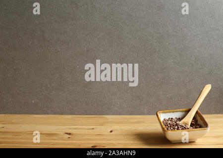Gesundes Essen Linsen mit Löffel in eine Schüssel auf Holztisch mit grauer Hintergrund Stockfoto