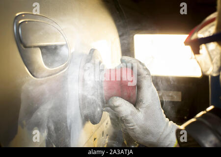 Hände Schleifen Polieren Sie das Auto. Karosserie Reparatur Stockfoto