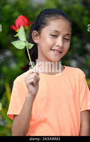 Weibliche Teenager und Glück mit einer Rose Stockfoto