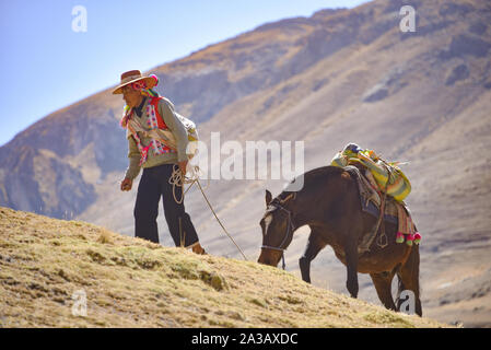 Reiter in der traditionellen Quechua Kleid nach Spuren durch die Anden. Ausangate Trail, Cusco, Peru Stockfoto