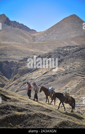 Reiter in der traditionellen Quechua Kleid nach Spuren durch die Anden. Ausangate Trail, Cusco, Peru Stockfoto