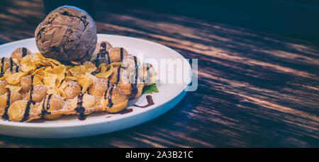 Waffel mit Schokolade Eis, Banane und Sahne abwischen. Schokolade Kaffee Eis Ball Stockfoto