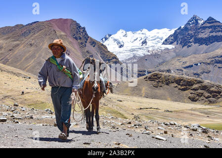 Reiter in der traditionellen Quechua Kleid nach Spuren durch die Anden. Ausangate Trail, Cusco, Peru Stockfoto