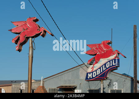 Side-by-Side vintage Mobil Pegasus (Flying Horse) Tankstelle insigias entlang einer Straße im Osten von Texas Stockfoto