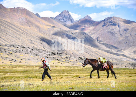 Reiter in der traditionellen Quechua Kleid nach Spuren durch die Anden. Ausangate Trail, Cusco, Peru Stockfoto