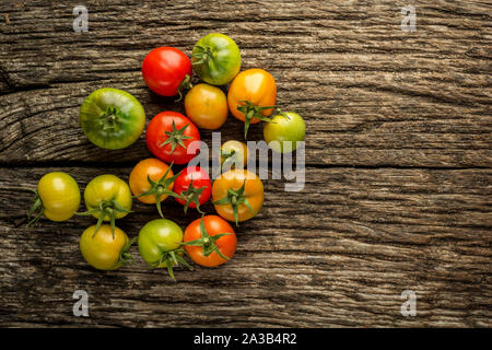 Verschiedene Sorten von bunten Tomaten auf rustikalen Hintergrund mit kopieren. Flach Stockfoto