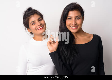 Zwei glückliche junge schöne Persische Frauen zusammen lächeln Stockfoto