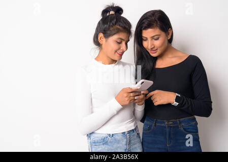 Zwei glückliche junge schöne Persische Frauen zusammen mit Phone Stockfoto