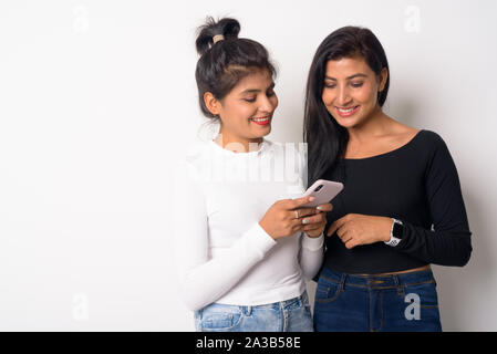 Zwei glückliche junge schöne Persische Frauen zusammen mit Phone Stockfoto