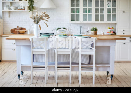 Schöne weiße Küche aus Holz mit Tisch und Stühlen Stockfoto