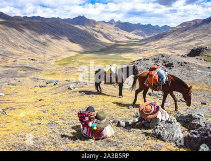 Reiter in der traditionellen Quechua Kleid nach Spuren durch die Anden. Ausangate Trail, Cusco, Peru Stockfoto