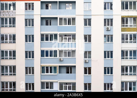 Fassade der Eigentumswohnung. Mehrstöckiges Wohnhaus. Abstrakte Textur. Wand mit Fenstern und Balkonen der Russischen und Ukrainischen Design, Architekt Stockfoto