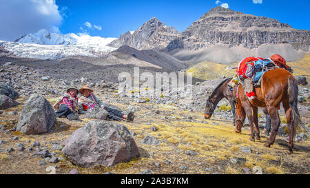 Reiter in der traditionellen Quechua Kleid nach Spuren durch die Anden. Ausangate Trail, Cusco, Peru Stockfoto