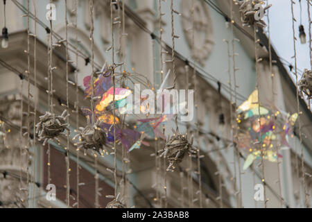 Festliche Straße eingerichtet. Leuchtende Girlanden der Lichter. Magische Atmosphäre. Verschwommen city street Hintergrund mit Weihnachtsbeleuchtung. Stockfoto