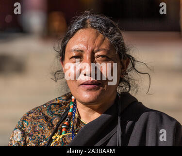 Eine ältere tibetische Frau Rosenkranz im Norbulingka Palast auf einem buddhistischen Pilgerweg in Lhasa, Tibet. Stockfoto