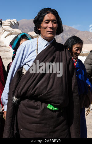 Ein tibetisch-buddhistischer Mann aus der Region Kham im Osten von Tibet auf einer Pilgerfahrt zu den Potala Palast in Lhasa, Tibet, das Tragen eines traditionellen Kopfschmuck. Stockfoto