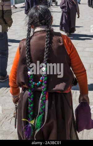 Ein khamba Tibetischen Frau aus der Kham Region Tibet auf einer Wallfahrt heiligen Stätten in Lhasa, Tibet zu besuchen, gehen rund um den Potala Palast. Stockfoto