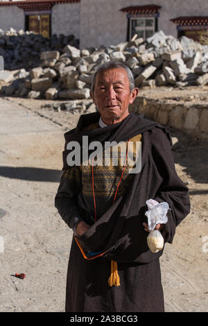 Eine ältere tibetische Mann auf einer Pilgerreise das Drepung Kloster, einem buddhistischen Kloster im Tal in der Nähe von Lhasa, Tibet zu besuchen. Stockfoto