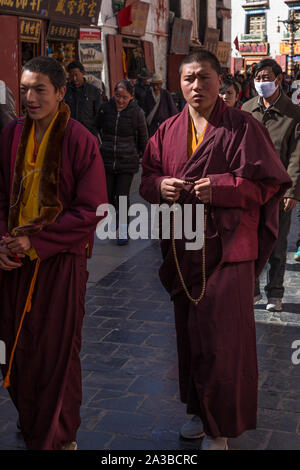 Junge Tibetische buddhistische Mönche gehen rund um den Jokhang Tempel Kora in Lhasa, Tibet, Durchführung von Mala Rosenkranz und beten, wie Sie gehen. Stockfoto