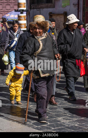 Ein tibetisch-buddhistischer Pilger in einen goldenen Faden hat aus der Region Kham im Osten von Tibet gehen rund um den Jokhang Tempel in Lhasa, Tibet. Stockfoto