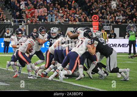 LONDON, ENGLAND - Oktober 06, 2019: Quarterback Verfolgung Daniel der Chicago Bears Hände weg zu laufen - zurück David Montgomery während der NFL Spiel zwischen Chicago Bears und die Oakland Räuber an der Tottenham Stadion in London, Vereinigtes Königreich. Stockfoto