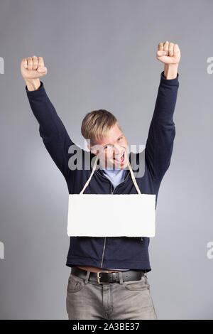 Erfolgreicher Mann zeigt leeres Namensschild aufgeregt. Stockfoto