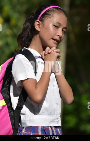 Filipina Mädchen Student im Gebet mit Notebooks Stockfoto