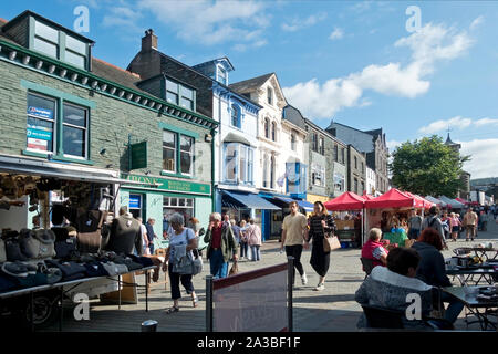 Menschen Touristen Besucher an den Outdoor-Donnerstag Marktstände im Sommer Market Square Keswick Cumbria England Großbritannien GB Großbritannien Stockfoto