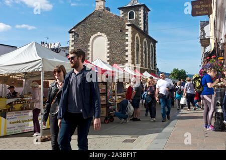 Menschen Touristen Besucher Spaziergang entlang Outdoor Donnerstag Marktstände im Sommer Market Square Keswick Cumbria England Großbritannien Großbritannien Stockfoto