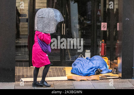 Preston, Lancashire. Oktober 2019. Wetter in Großbritannien. Raue Schlafwagen in der Ladentür ein nasser, kalter, blutriger Start in den Tag im Stadtzentrum von Preston. IPEOPLE passiert Bettler, Obdachlose und Obdachlose, Menschen, die auf den Straßen leben, Türsteher, Schlafen, Armut, Arbeitslosigkeit, Wohlergehen, Bettler, rascher Tramp, Hobo, Bum, Vagabund. Unglückliche Person in Armut, armer Vagrant, Tramp, Drifter, schäbig, zerbrochen, zerbrochen, zerbrochen, zerbrochen, zerbrochen. Stockfoto