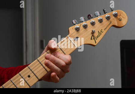 Kerl spielen bei Fender Stratocaster E-Gitarre Stockfoto