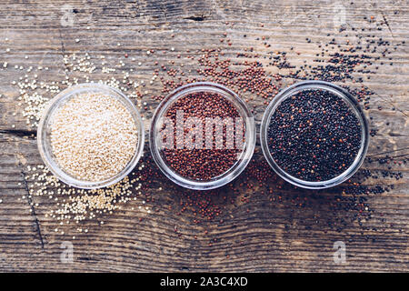 Schwarz, Rot und Weiß Quinoa Körner auf Holz- Hintergrund. Gesundes Essen. Ansicht von oben. Stockfoto