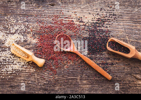 Schwarz, Rot und Weiß Quinoa Körner auf Holz- Hintergrund. Gesundes Essen. Ansicht von oben. Stockfoto